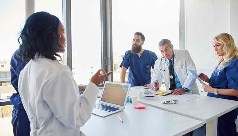 A group of doctors sitting around a table.