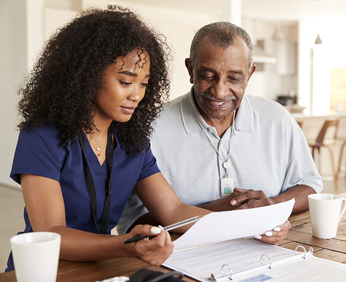 A woman and an older man looking at papers.